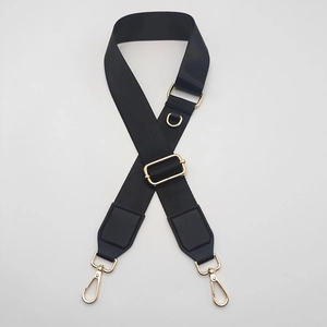 Detail of adjustable black nylon shoulder strap with gold metal D-ring and swivel clips