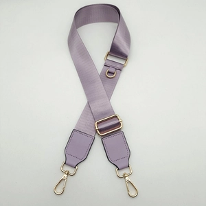 Close-up of lavender nylon bag strap with golden metal hooks and D-ring connector