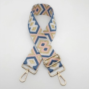 Close-up of ethnic geometric jacquard bag strap with gold metal swivel snap hooks