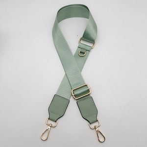 Detail of mint green nylon bag strap with gold metal D-ring and swivel lobster clasps