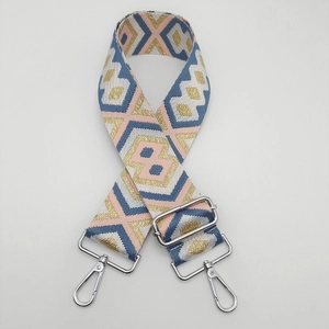 Macro detail of ethnic style woven bag strap with pink and navy geometric pattern