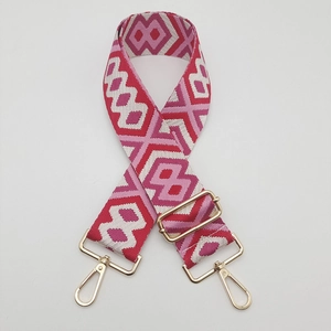 Detail view of ethnic diamond pattern wide canvas bag strap with golden metal lobster hooks