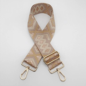 Close-up of geometric ethnic pattern woven nylon strap with gold metal lobster clasps