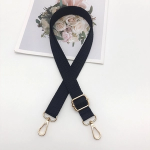 Adjustable black jacquard woven bag strap with golden metal hooks and floral texture