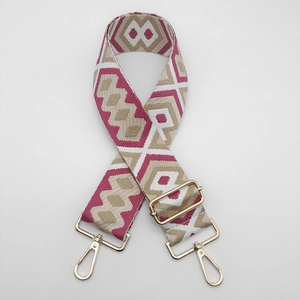 Detail of adjustable geometric canvas shoulder strap with golden metal swivel hooks