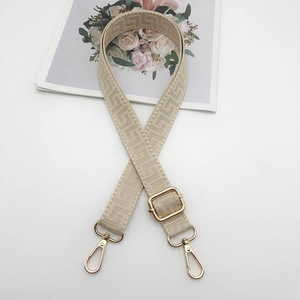Adjustable beige woven bag strap with coffee geometric pattern and gold metal hooks