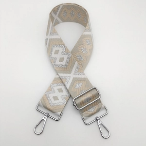 Close-up of ethnic woven nylon bag strap with geometric patterns and silver metal hooks