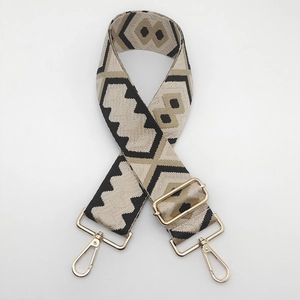 Detail of adjustable geometric diamond pattern canvas bag strap with gold metal hooks