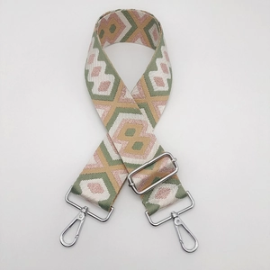 Close-up of ethnic geometric pattern nylon bag strap with silver metal swivel hooks