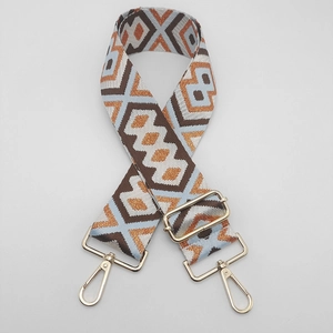 Close-up of ethnic geometric nylon bag strap with gold metal hooks and adjustable ring