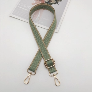 Close-up of adjustable 2.5cm sage green and beige geometric jacquard bag strap detail