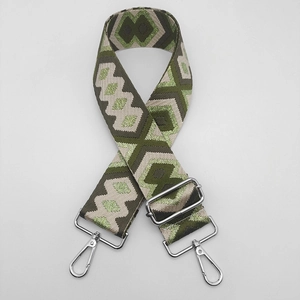 Detail of ethnic style green geometric woven bag strap with silver metal lobster hooks
