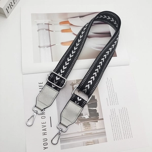 Detail of adjustable black shoulder strap with silver arrow pattern and metal swivel hooks
