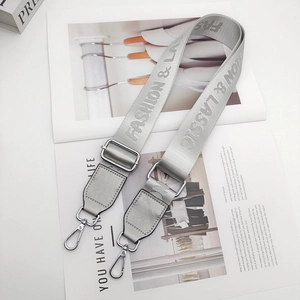 Detail of silver gray adjustable bag strap with Fashion & Classic lettering and metal hooks