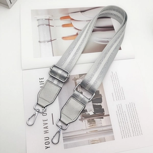 Detail of adjustable silver glitter bag strap with polished metal swivel hooks and buckles