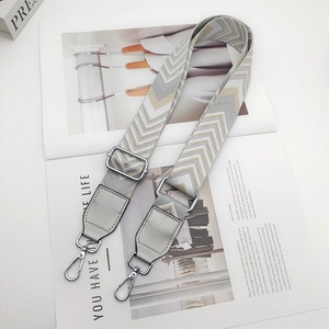 Adjustable woven chevron handbag strap with silver hardware and grey faux leather