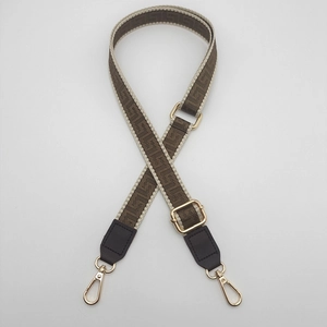 Adjustable geometric woven bag strap with golden metal clasps and brown leather ends