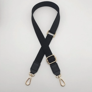 Close-up of adjustable black woven bag strap with golden metal hooks and leather joints