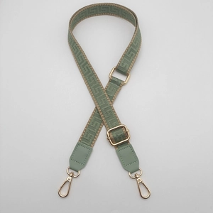Adjustable sage green woven bag strap with geometric jacquard pattern and gold clips