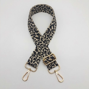 Adjustable leopard print shoulder strap with gold metal swivel hooks and wide webbing