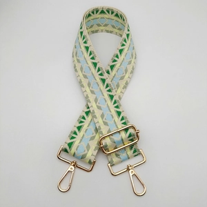 Close-up of ethnic geometric woven bag strap in green and blue with gold hardware