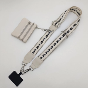 Detail of adjustable beige phone strap with geometric pattern and mini coin purse