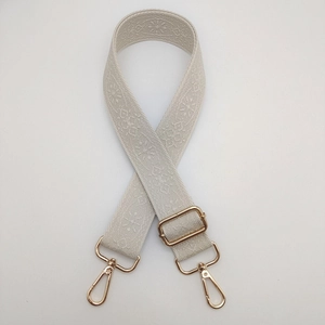 Detail eines beigen Vintage-Jacquard-Gurtes mit verstellbaren hellgoldenen Metallschnallen