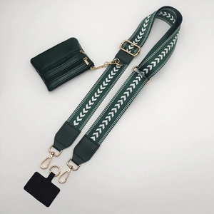 Detail of adjustable dark green woven strap with a leather coin purse and golden hardware