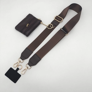Detail view of brown wide shoulder strap with detachable mini purse and gold hardware