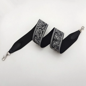 Adjustable black woven shoulder strap with white paisley embroidery and silver metal hooks