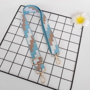 Adjustable canvas shoulder strap with blue and tan geometric patterns and gold clips