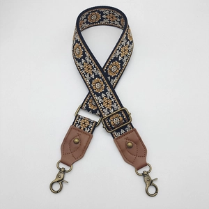 Detail of bohemian jacquard bag strap with blue and yellow patterns and bronze metal hooks