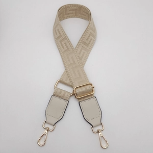 Detail of adjustable woven bag strap with Greek key pattern and gold lobster clips