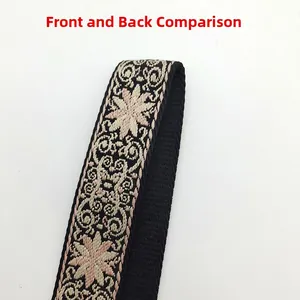 Close-up of double-sided ethnic floral woven bag strap with pink embroidery and black texture
