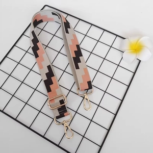 Adjustable wide canvas shoulder strap with pink and grey geometric weaving and gold hooks