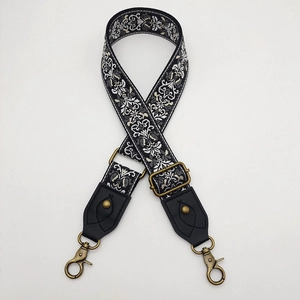 Detail view of retro jacquard wide bag strap with bronze metal hooks and floral pattern