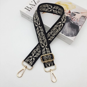 Detail of embroidered ethnic bag strap with vintage pattern and gold metal hardware