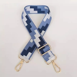 Detail of adjustable blue pixel weave canvas bag strap with gold metal lobster clasps