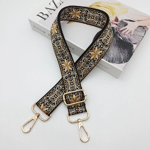 Close-up of vintage floral jacquard bag strap with gold metal swivel lobster clasps