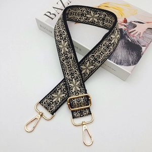 Close-up of bohemian floral jacquard strap with gold hardware on fashion magazine