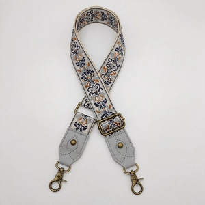 Detail of bohemian jacquard woven bag strap with bronze metal swivel hooks and leather ends