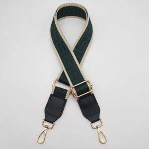 Detail of adjustable woven purse strap with Greek pattern and gold metal lobster clasps