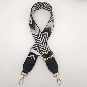 Adjustable geometric woven canvas shoulder strap with gold metal hooks and black leather ends