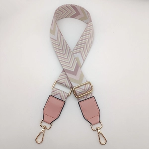 Detail of adjustable woven canvas strap with pink V-pattern and gold lobster clasps