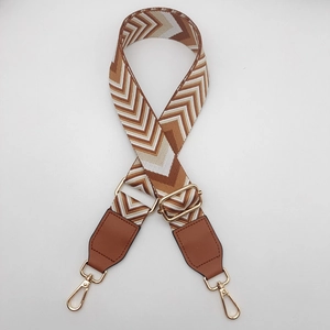 Detail showing colorful woven chevron strap with brown leather ends and gold metal hooks