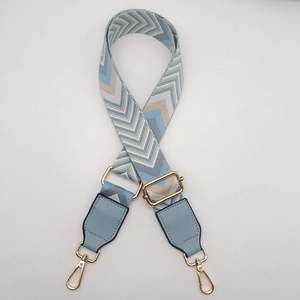 Detail of adjustable woven blue wave strap with gold metal hooks and leather trim