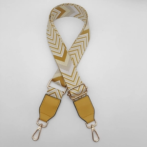Close-up of yellow chevron woven strap with adjustable gold hardware and leather ends