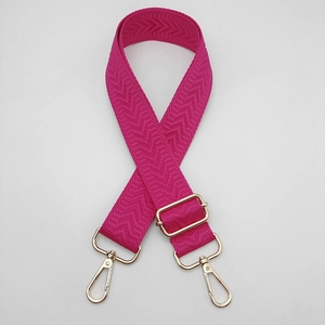 Détail de la bandoulière rose rouge à motif chevrons avec boucles dorées réglables