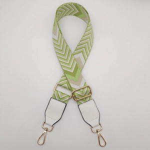 Close-up of adjustable wide canvas bag strap with green and beige geometric V-pattern