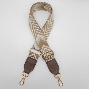 Adjustable chevron patterned canvas strap with brown leather ends and gold metal clips
